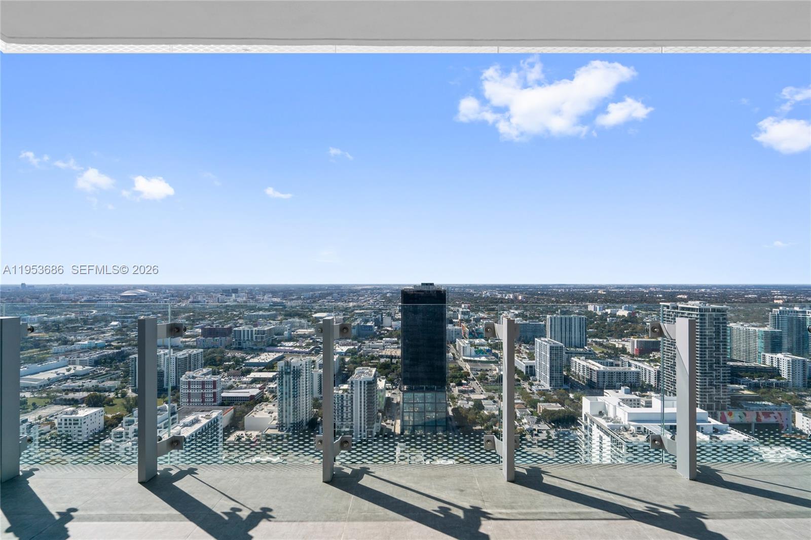 A high-rise balcony overlooks a dense city skyline under a clear blue sky — 700 NE 26th Ter # 4903, Miami FL 33137, MIAMI, FL