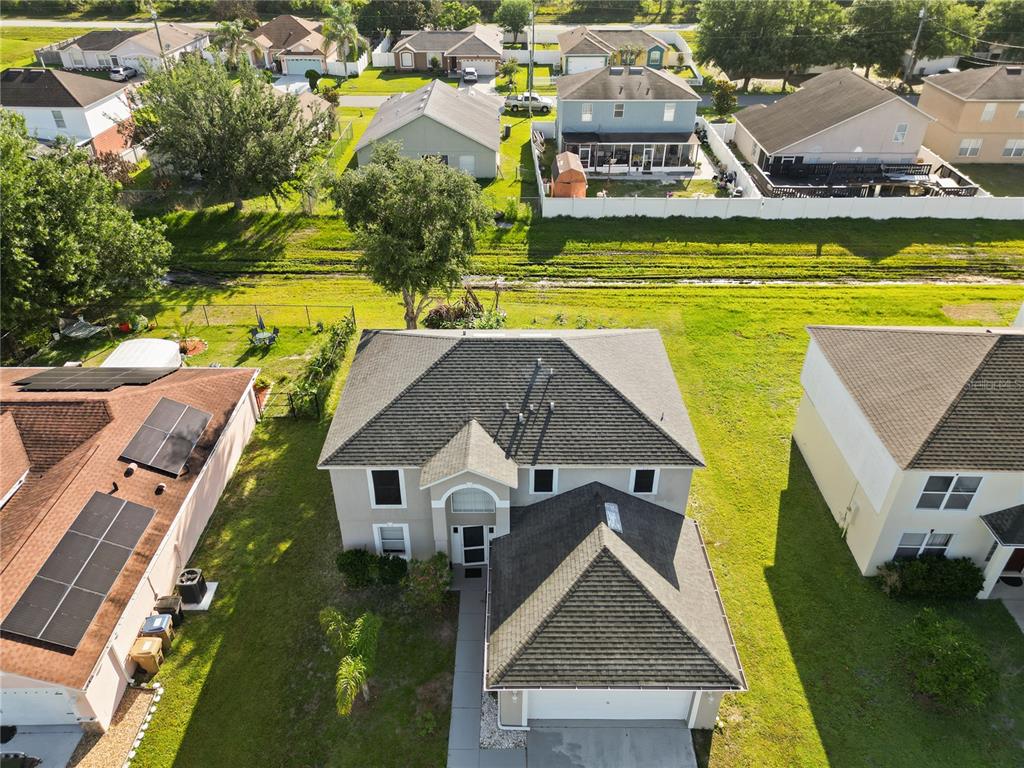An aerial view of a suburban house with a gray roof and a front garage — 613 NOTRE DAME WAY, KISSIMMEE, FL