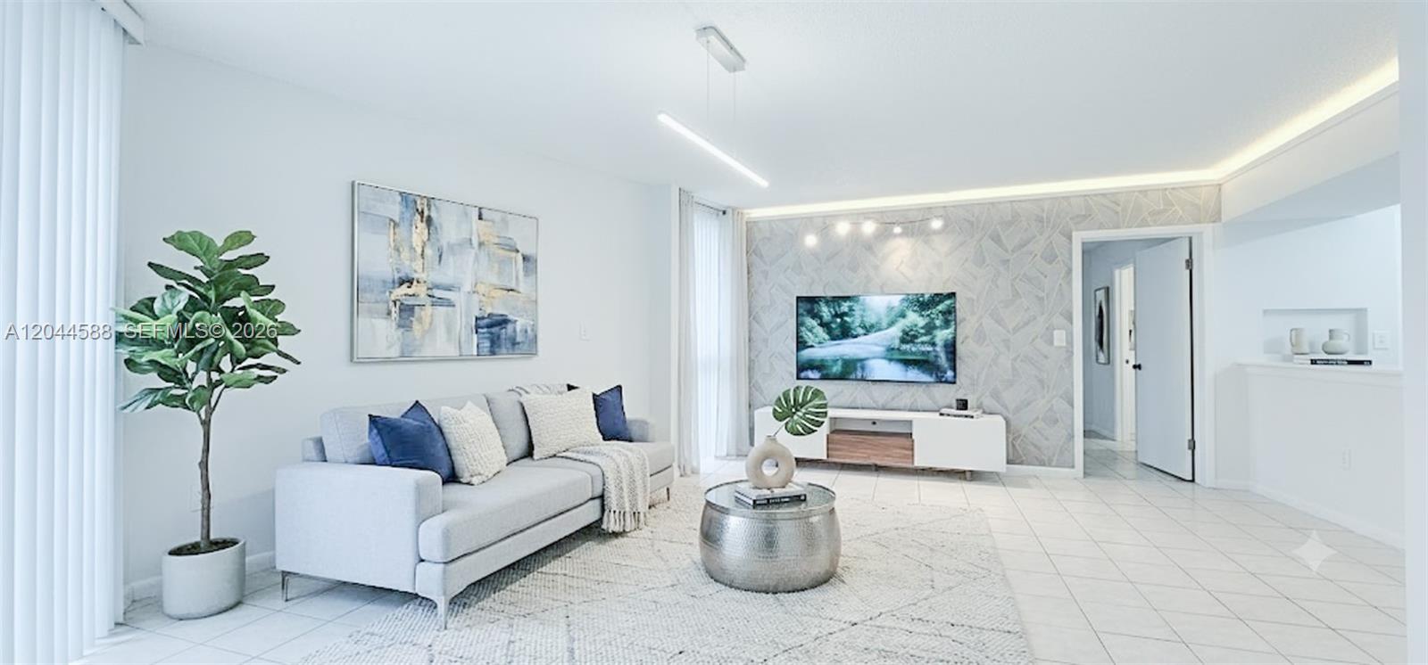 A modern living room features a grey sofa, a patterned accent wall, and tiled flooring — 7035 NW 186th St # D110, Hialeah FL 33015, HIALEAH, FL