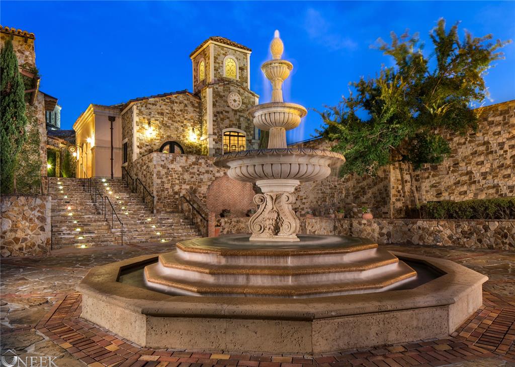 A stone fountain sits in a courtyard in front of a multi-level stone building — 15381 APENNINE WAY, MONTVERDE, FL