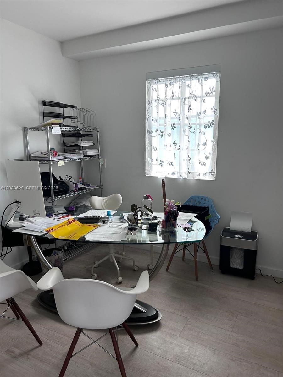 A home office features a glass-topped desk, white chairs, a metal shelving unit, and a shredder — 700 16th St # 109, Miami Beach FL 33139, MIAMI BEACH, FL