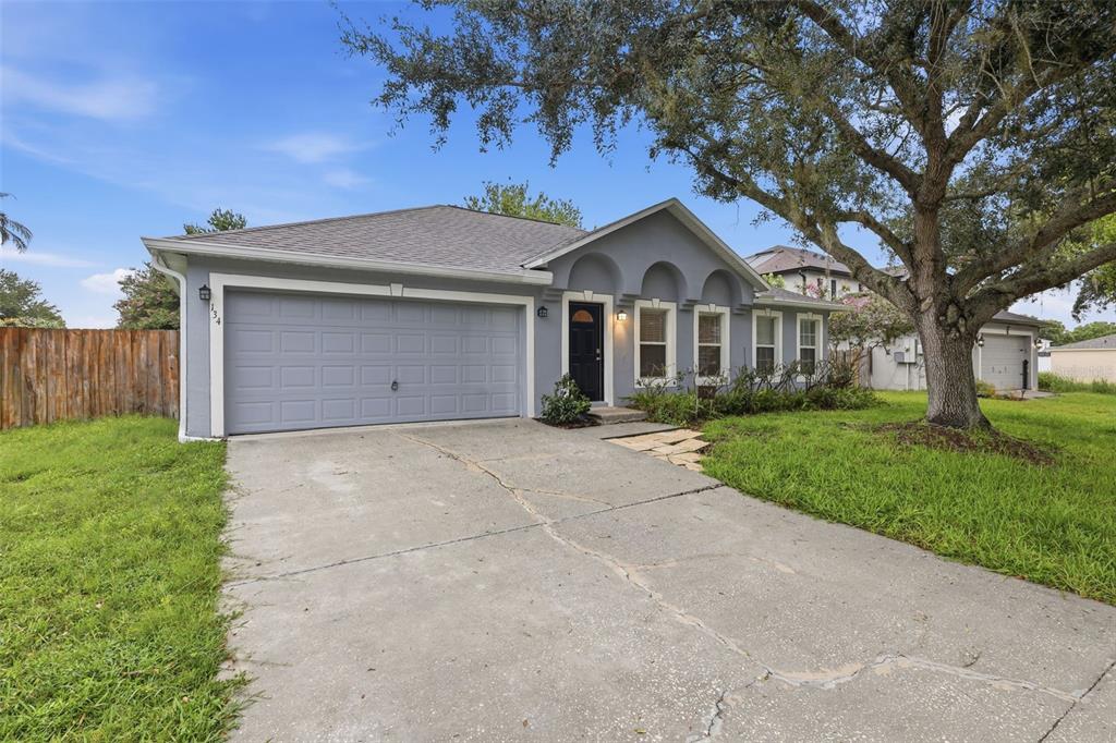 A dining room features light wood-look flooring, two arched wall niches, and a modern chandelier — 134 CROWN COLONY WAY, SANFORD, FL