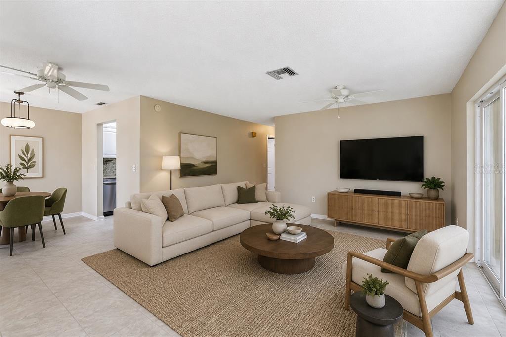A living room features a beige sectional sofa, a round coffee table, and a television — 1418 14TH CIRCLE SE, LARGO, FL
