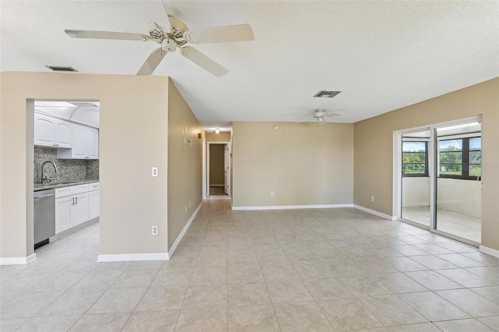 An open-concept living area with tile flooring, a ceiling fan, and an adjacent kitchen — 1418 14TH CIRCLE SE, LARGO, FL