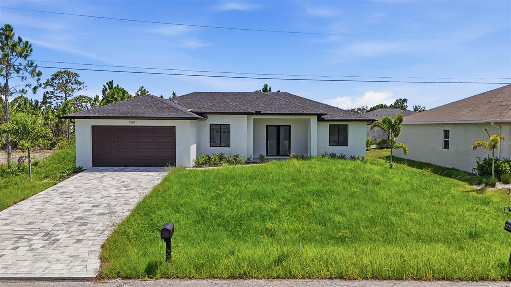 A single-story house with a white exterior, dark roof, and a paved driveway — 14041 NEWSON LANE, PORT CHARLOTTE, FL