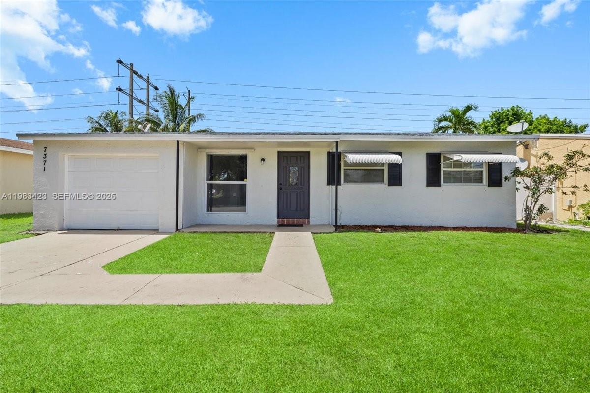 A single-story house with a white exterior, a garage, and a front lawn — 7371 SW 1st St, Margate FL 33068, MARGATE, FL