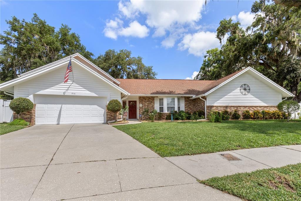A single-story house with a brick and white siding exterior, a garage, and a lawn — 1516 TEAKWOOD DRIVE, PLANT CITY, FL