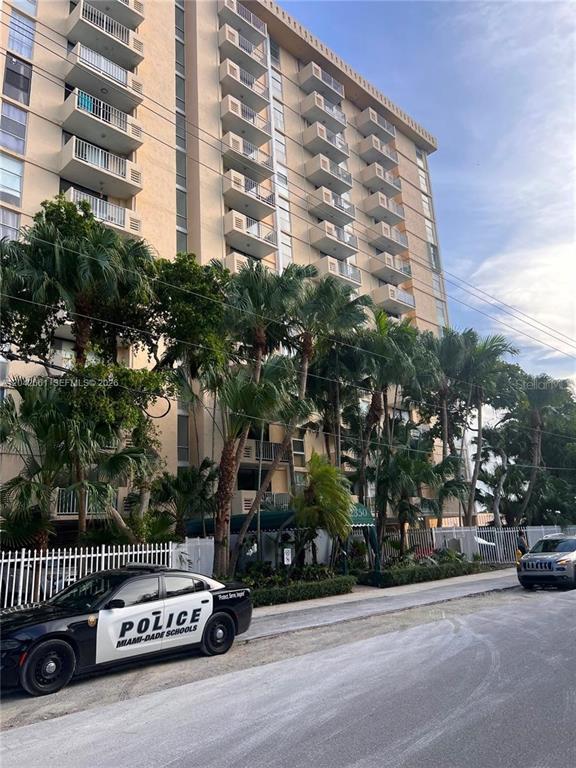 A Miami-Dade Schools police vehicle is parked in front of a multi-story apartment building — 2350 NE 135TH STREET UNIT 209, NORTH MIAMI, FL