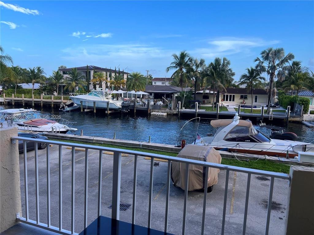 A balcony view overlooks a canal with docked boats and residential properties under a blue sky — 2350 NE 135TH STREET UNIT 209, NORTH MIAMI, FL