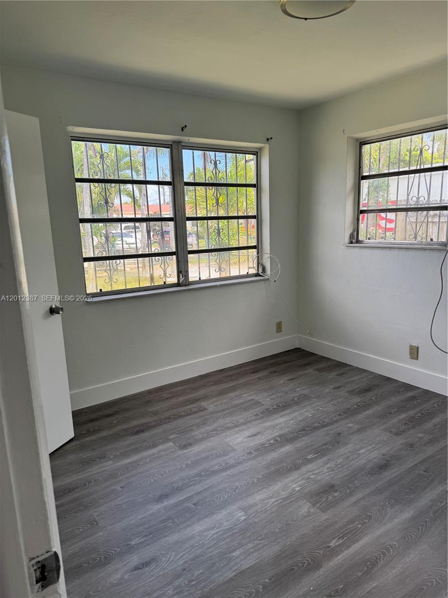 An empty room features light-colored walls, white baseboards, and dark wood-look flooring — 2620 SW 53rd Ave, West Park FL 33023, WEST PARK, FL