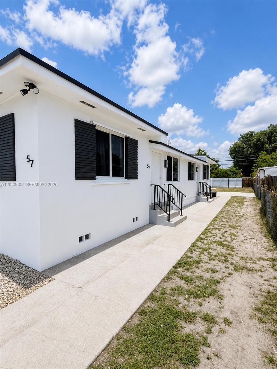 The exterior of a white single-story building features black shutters and two separate entrance staircases — 59 E 10th St, Hialeah FL 33010, HIALEAH, FL