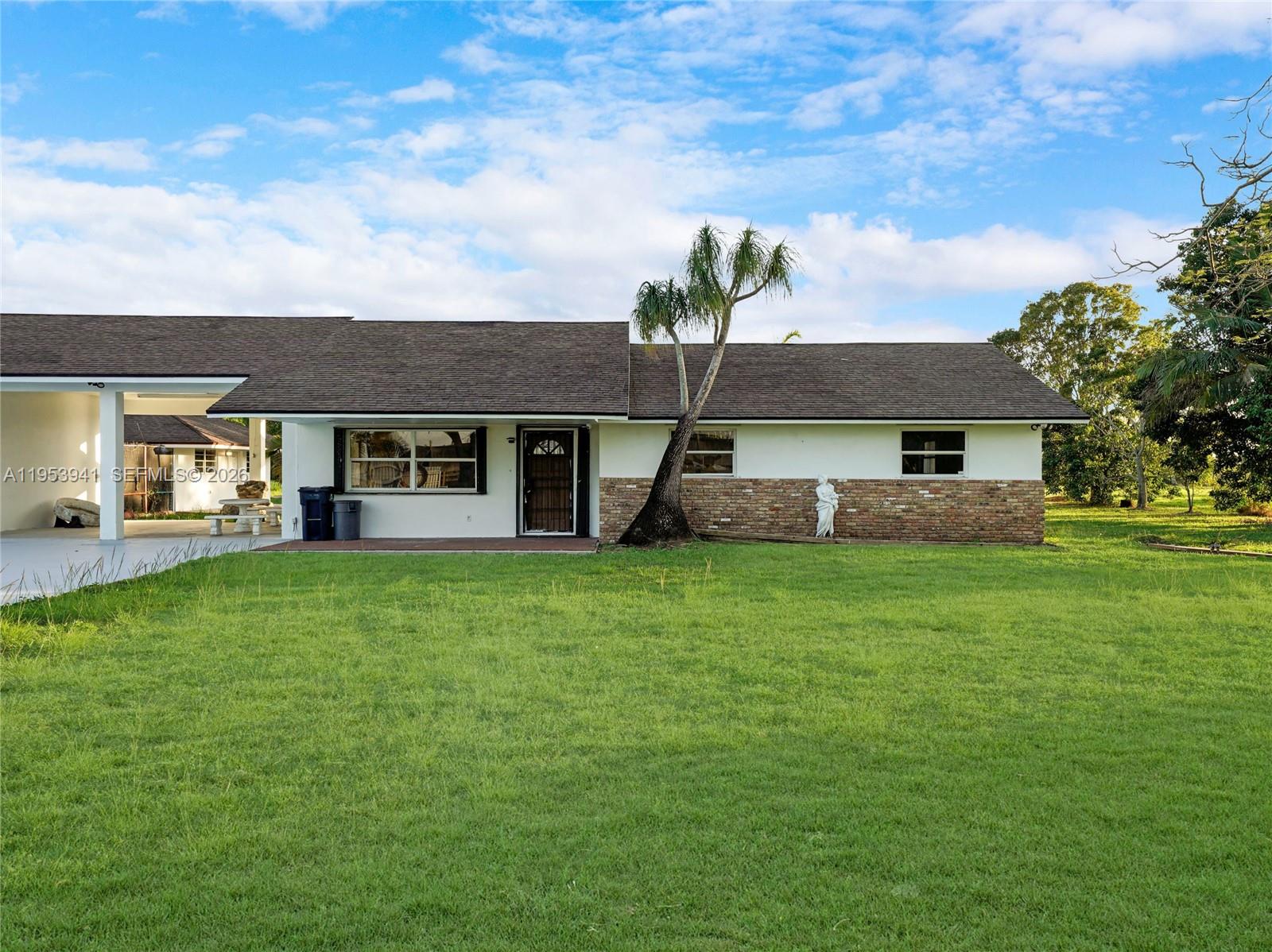 A single-story house with a brick facade, a palm tree, and a covered carport — 20000 SW 216th St, Miami FL 33170, MIAMI, FL