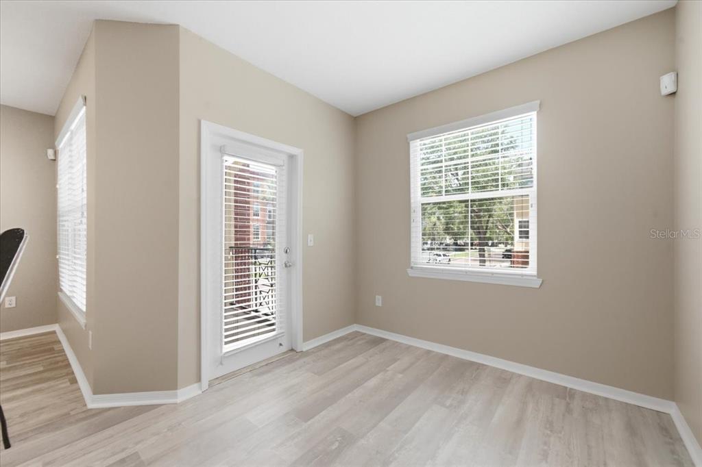 A kitchen with white cabinets, dark countertops, and stainless steel appliances overlooks a dining area — 1910 E PALM AVENUE UNIT 10205, TAMPA, FL