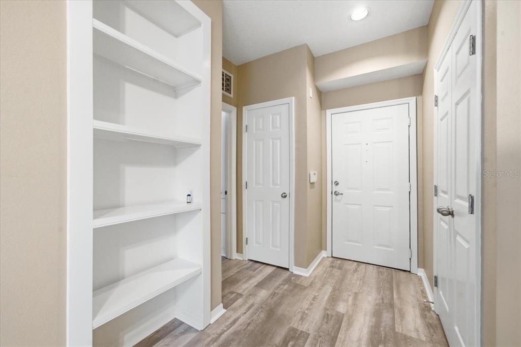 A kitchen features white cabinets, dark countertops, stainless steel appliances, and light wood-look flooring — 1910 E PALM AVENUE UNIT 10205, TAMPA, FL