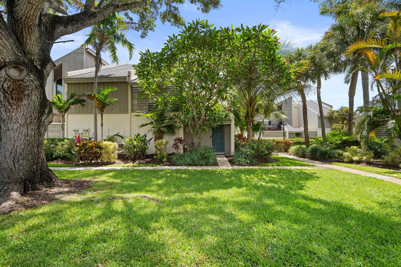 A multi-story residential building exterior surrounded by lush tropical landscaping and a large lawn — 1605 S Us Hwy 1 # 3h, Jupiter FL 33477, JUPITER, FL