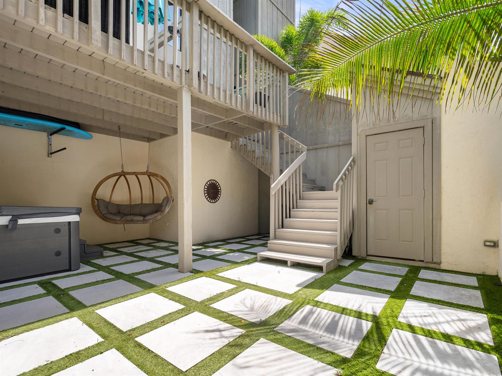 A patio features square pavers with artificial grass, a hanging chair, a hot tub, and stairs — 1605 S Us Hwy 1 # 3h, Jupiter FL 33477, JUPITER, FL
