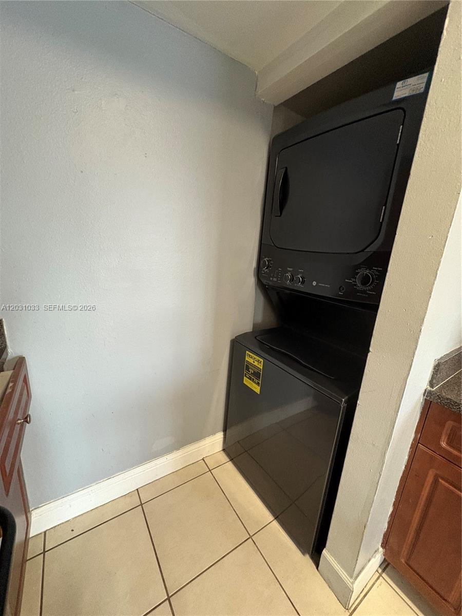 A stacked washer and dryer unit is installed in a small laundry alcove — 15231 SW 80th St # 602, Miami FL 33193, MIAMI, FL