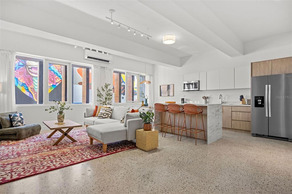 An open-concept living room and kitchen with a sectional sofa, breakfast bar, and mural view — 606 CERRA ST, SAN JUAN, PR