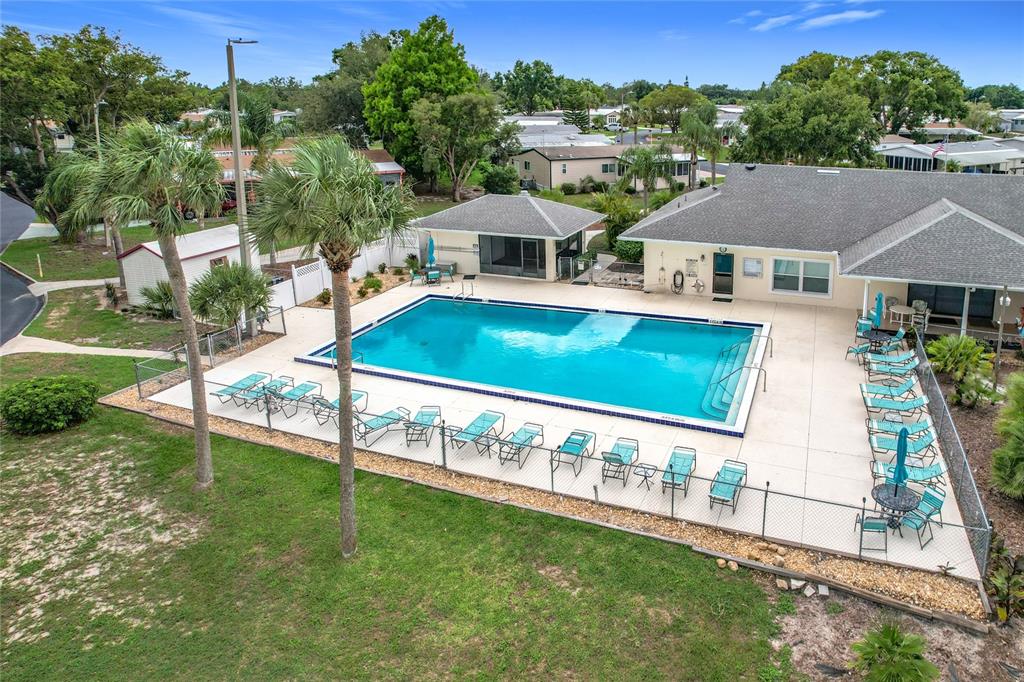 An aerial view shows a residential community with mobile homes surrounding a central pond — 6044 GRAND OAKS DRIVE SE, WINTER HAVEN, FL
