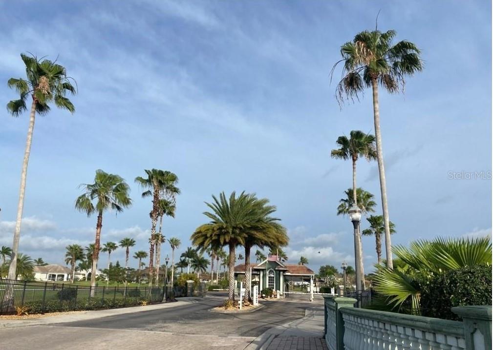 A gated entrance to a residential community features palm trees and a guard house — 18168 HORIZON VIEW BOULEVARD, LEHIGH ACRES, FL