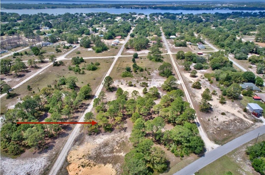An aerial view shows a wooded, undeveloped residential lot with dirt roads in a rural area — 328 TAHITI AVENUE, LAKE PLACID, FL