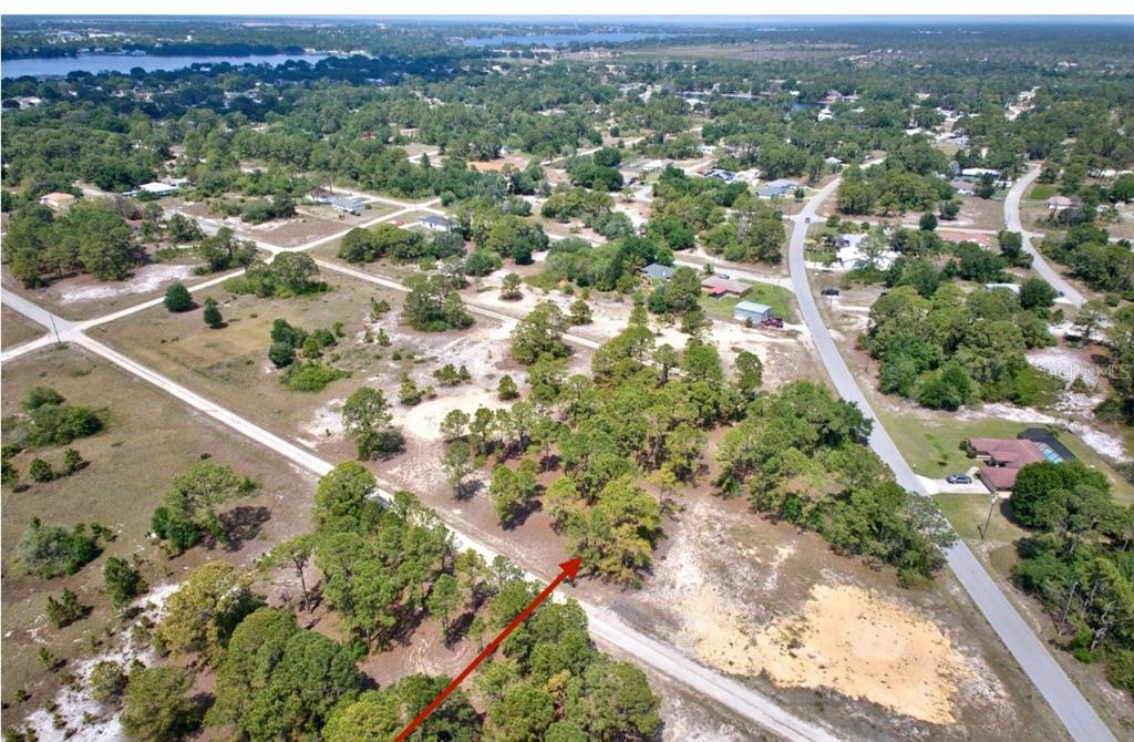 An aerial view of a vacant, wooded residential lot surrounded by roads and nearby houses — 328 TAHITI AVENUE, LAKE PLACID, FL