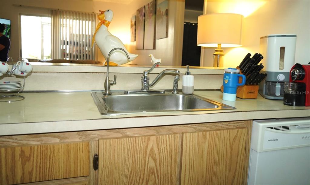 A kitchen sink with a faucet and water dispenser sits on a laminate countertop — 1664 SUNNY BROOK LANE NE UNIT 103, PALM BAY, FL