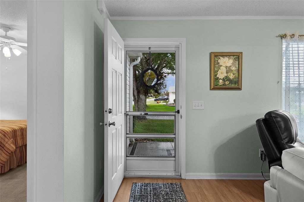 An interior view of a room with a white door, screen door, and light-colored walls — 8015 SE 174TH BELHAVEN LOOP, THE VILLAGES, FL