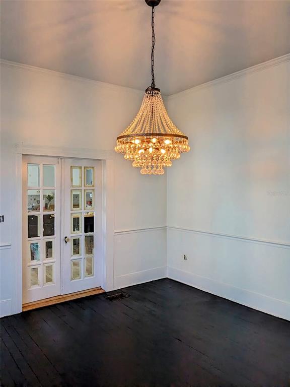 An entryway features a crystal chandelier, a white staircase, and two white interior doors — 495 E PARKER STREET, BARTOW, FL