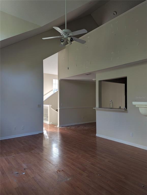 A living room with wood flooring, a vaulted ceiling, a ceiling fan, and a pass-through window — 5956 WESTGATE DRIVE UNIT 203, ORLANDO, FL