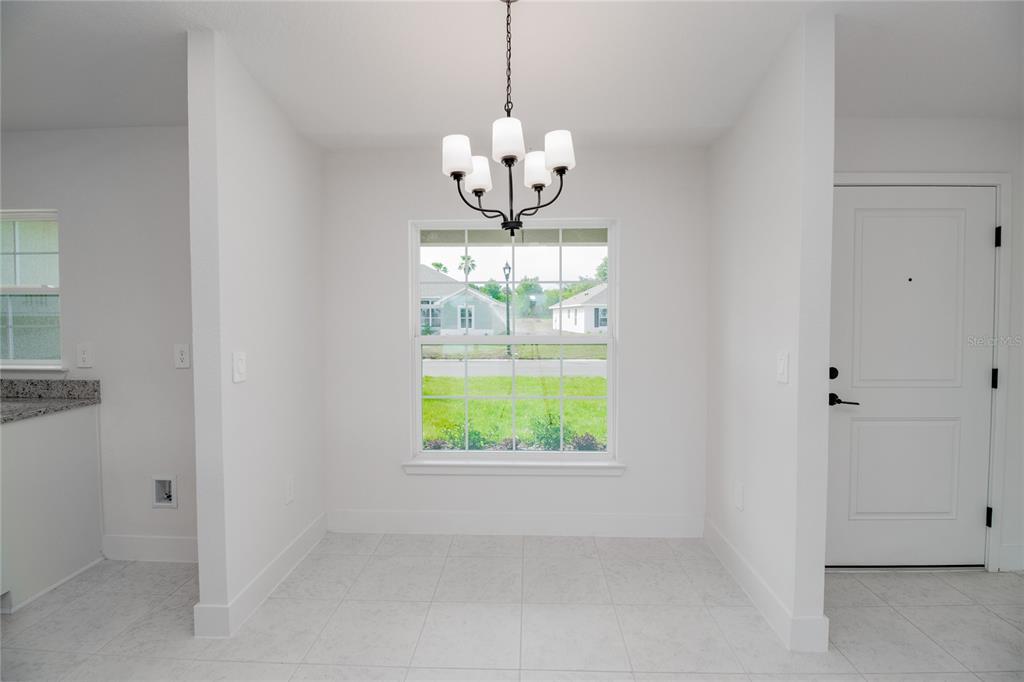 A dining area with white walls, tile flooring, a window, and a chandelier — 1218 HICKORY NUT DRIVE, LAKE WALES, FL