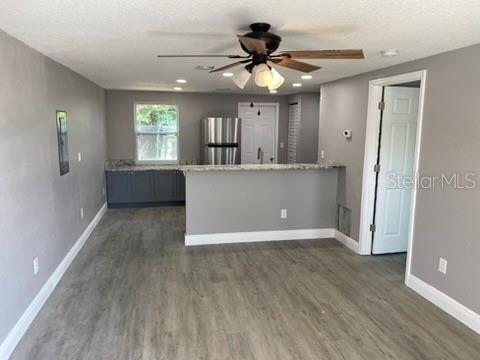 A kitchen with a breakfast bar, stainless steel refrigerator, and gray flooring in an open room — 110 KARDE LANE, BRANDON, FL