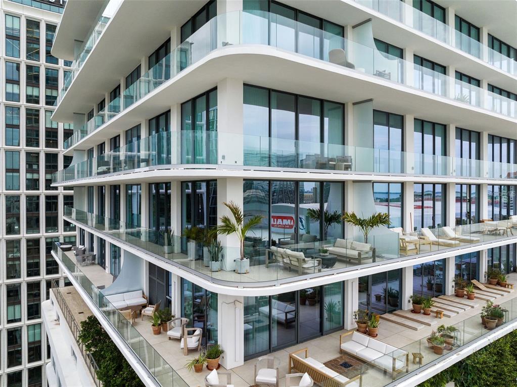 An exterior view of a modern apartment building featuring multiple levels of spacious, furnished balconies — 1000 WATER STREET UNIT 1103, TAMPA, FL