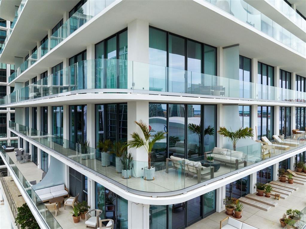 An exterior view of a modern apartment building featuring multiple balconies with glass railings — 1000 WATER STREET UNIT 1103, TAMPA, FL
