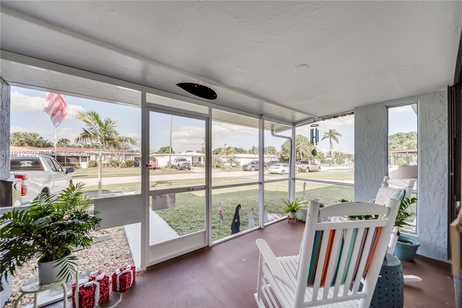 A living and dining area features light wood floors, a grey sofa, and light blue walls — 7440 Fillmore St, Hollywood FL 33024, HOLLYWOOD, FL