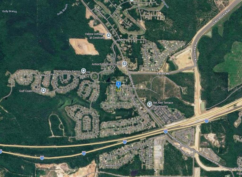 This is an aerial map view showing residential neighborhoods, roads, and surrounding wooded areas — 921 MARACEL LOOP, CRESTVIEW, FL