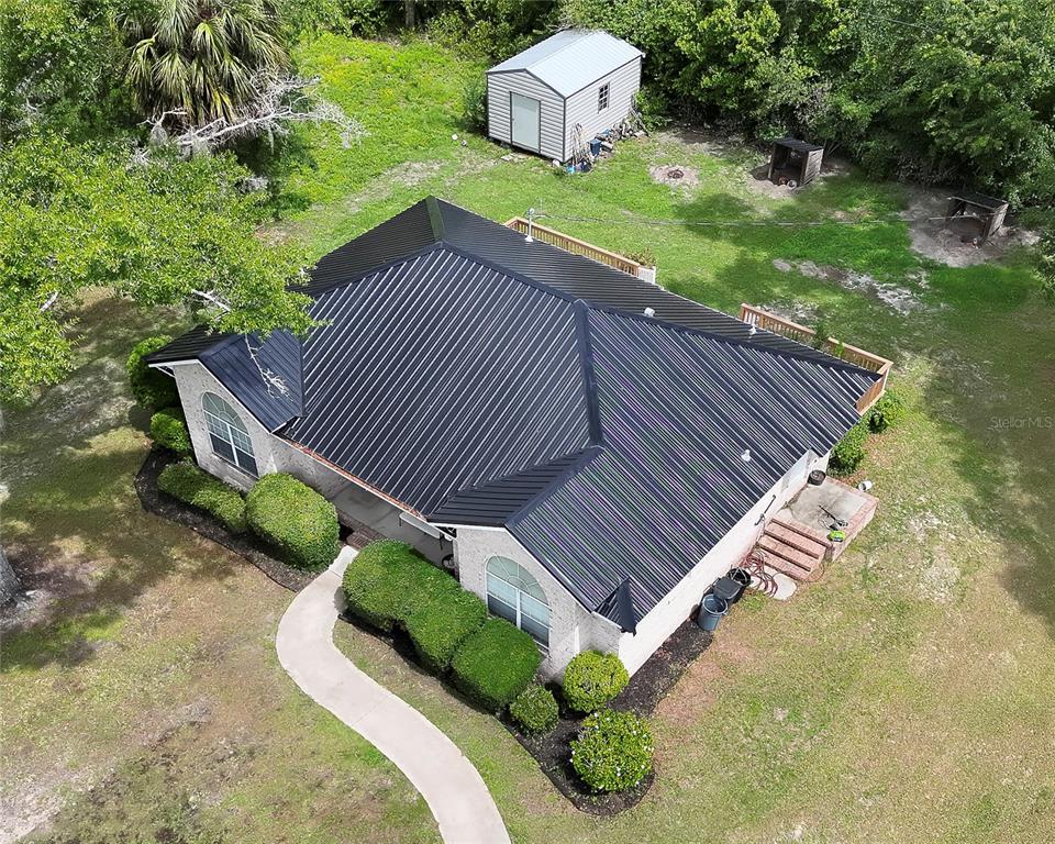 An aerial view shows a house with a black metal roof and a backyard shed — 1302 MAYRA ROAD SW, LIVE OAK, FL
