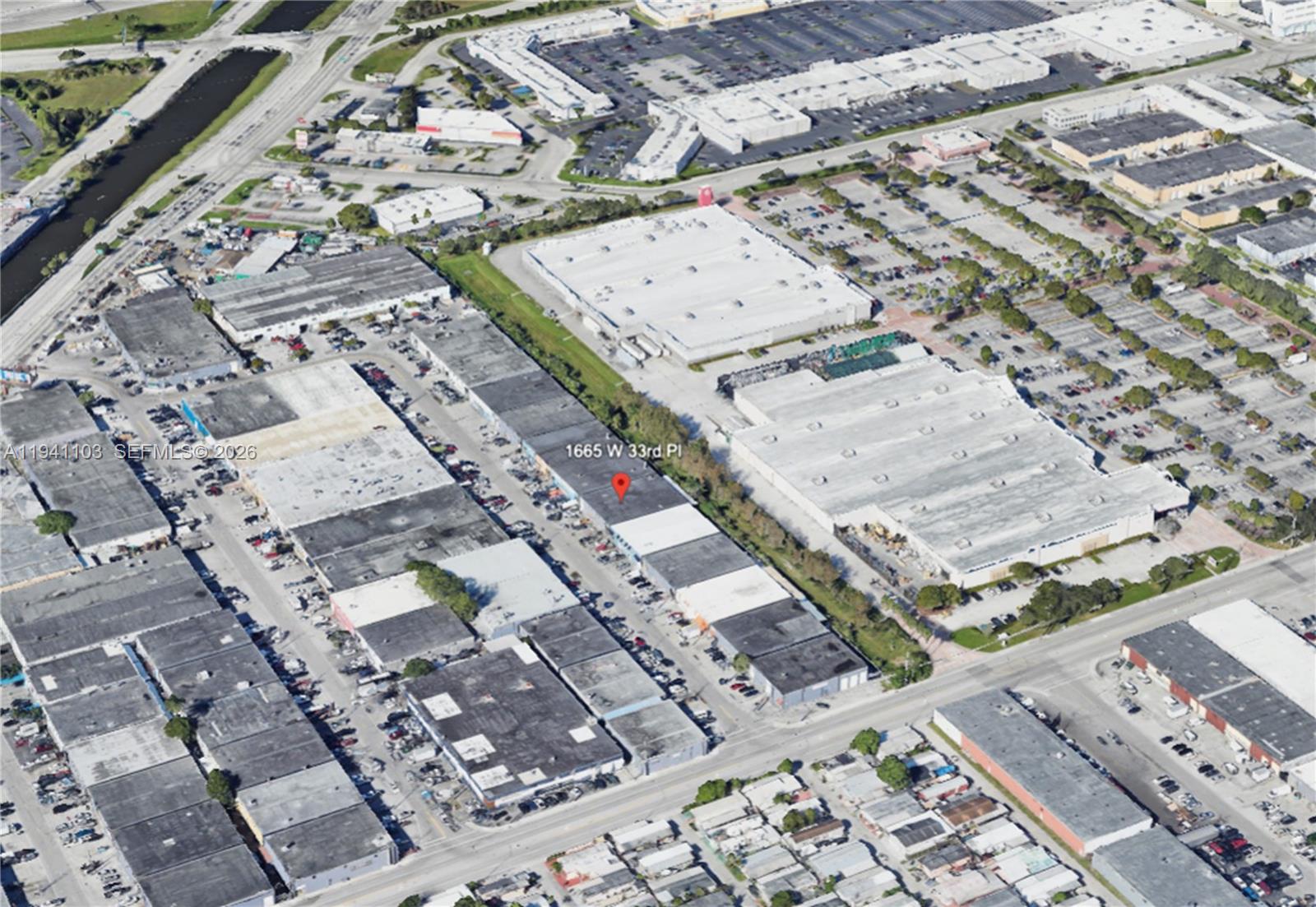 This aerial view shows a commercial warehouse complex with parking lots and surrounding industrial buildings — 1665 W 33rd Pl, Hialeah FL 33012, HIALEAH, FL