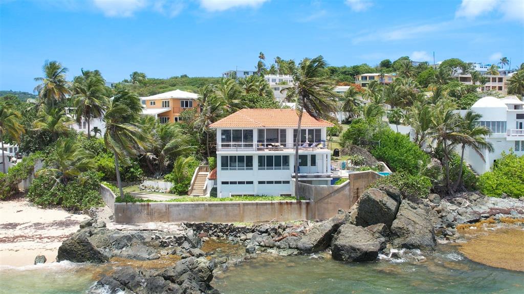 A two-story house with a tiled roof sits on a rocky coastline near palm trees — 294 BRAVOS DE BOSTON, VIEQUES, PR