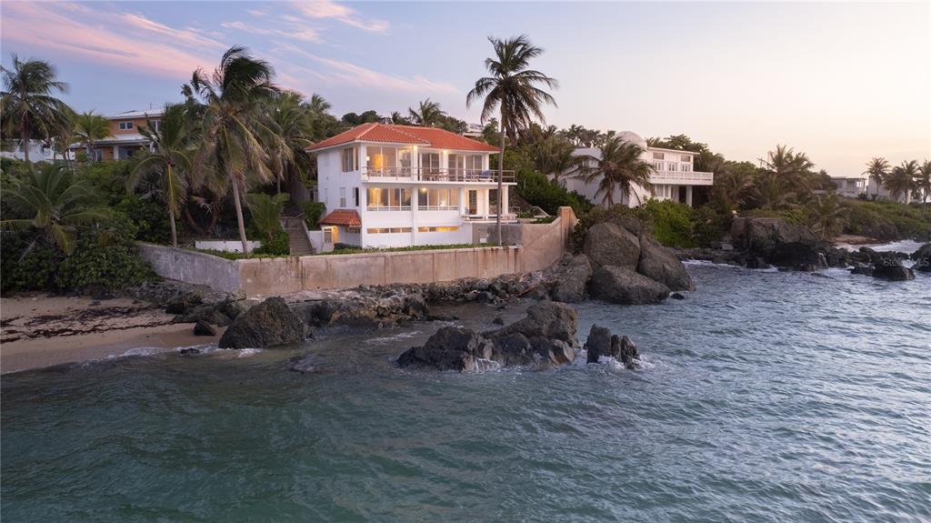 A white multi-story house with a red roof sits on a rocky coastline by water — 294 BRAVOS DE BOSTON, VIEQUES, PR