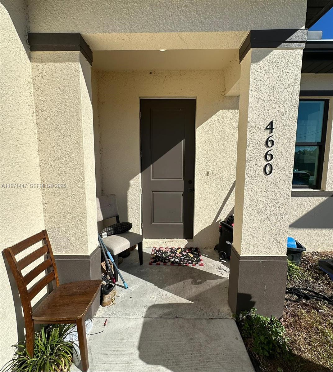 A front entryway features a brown door, a wooden chair, and a house number 4660 — 4662 SW 26th st # 4662, Lehigh Acres FL 33973, LEHIGH ACRES, FL