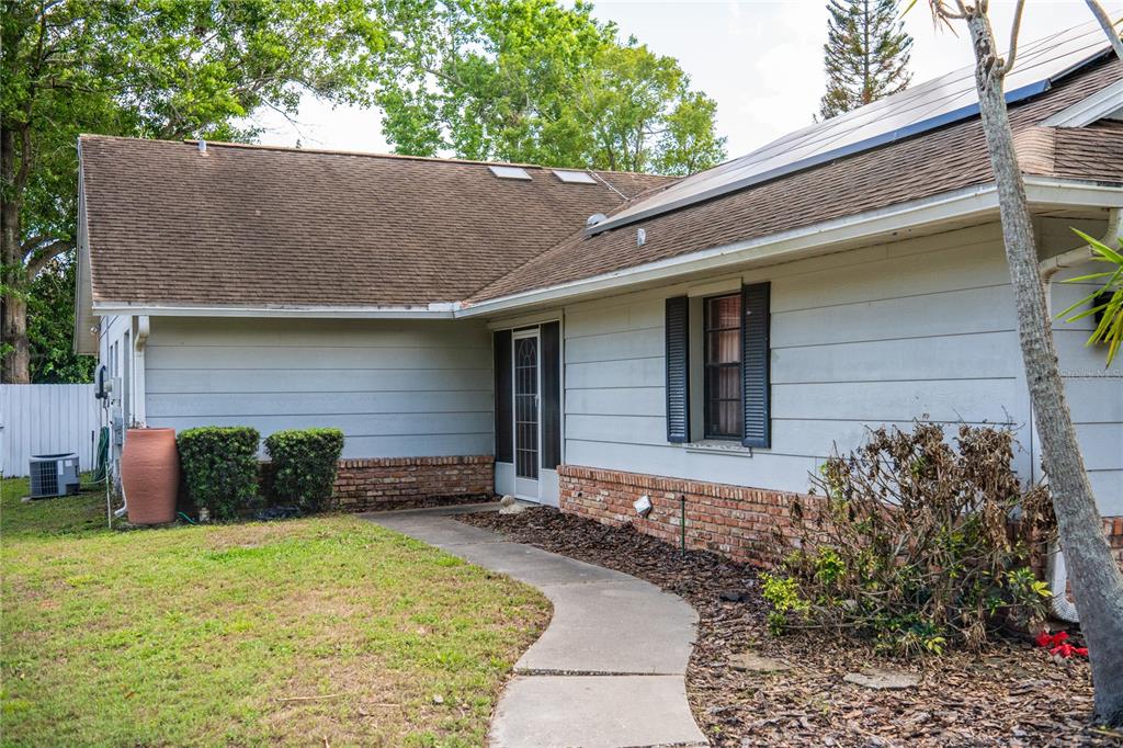 A single-story house with light gray siding, brick accents, and a concrete walkway — 7802 RICHWOOD DRIVE, ORLANDO, FL