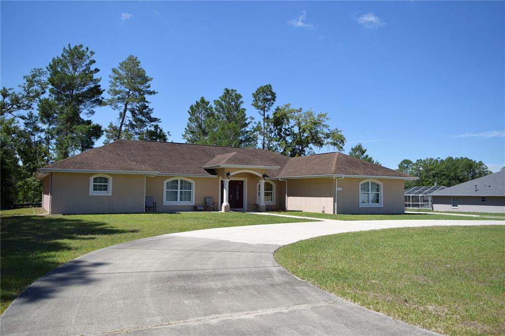 A single-story tan house with a brown roof and a curved concrete driveway — 4714 SW 114TH PLACE, OCALA, FL
