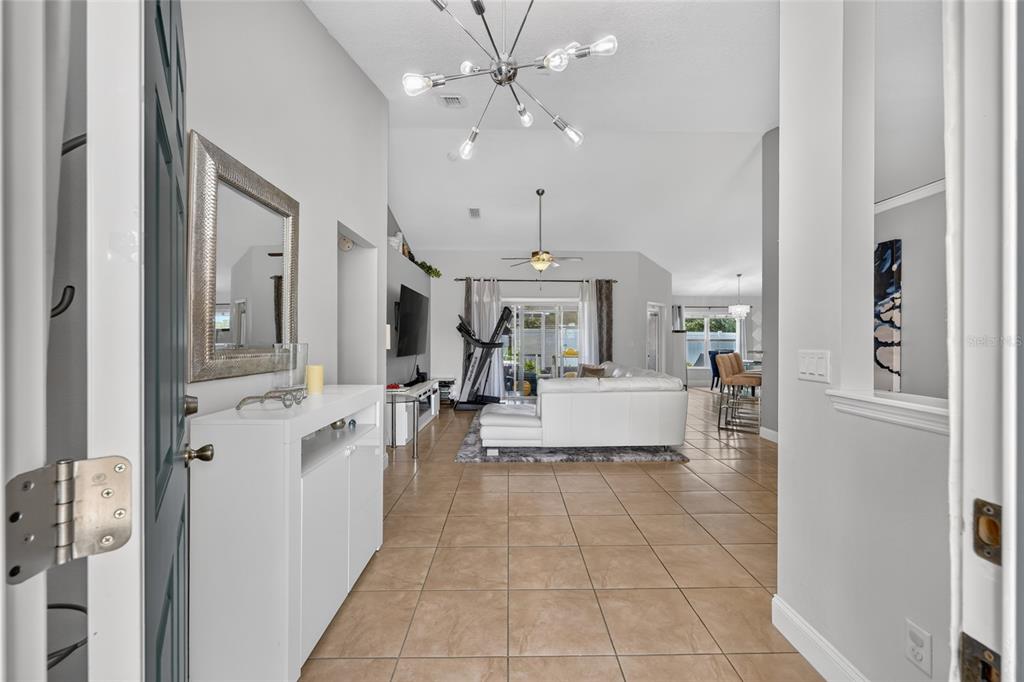 An entryway leads into a bright living room with tile floors and a white sofa — 5294 SW 97TH LANE ROAD, OCALA, FL