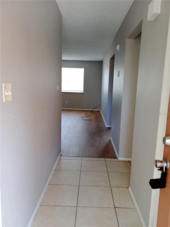 A tiled entryway leads into a living area with wood-look flooring and a window — 2190 KNOX MCRAE DRIVE UNIT F, TITUSVILLE, FL