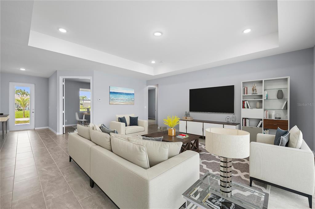 A living room features light tile floors, a tray ceiling, and a large sectional sofa — 14148 SLICHTER AVENUE, PORT CHARLOTTE, FL