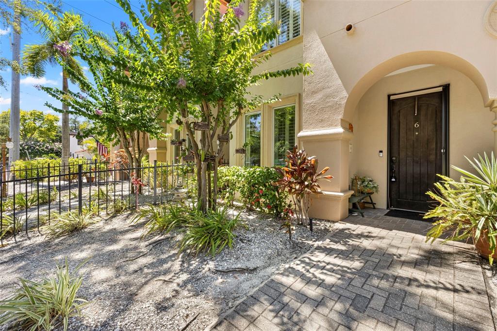 A paved walkway leads to the arched entryway of a house with a dark door — 3819 W DALE AVENUE UNIT 6, TAMPA, FL