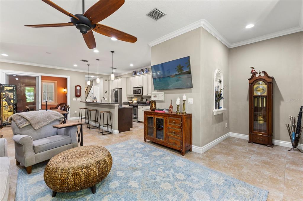 A living room with a ceiling fan, a wall-mounted television, and an open kitchen — 3819 W DALE AVENUE UNIT 6, TAMPA, FL