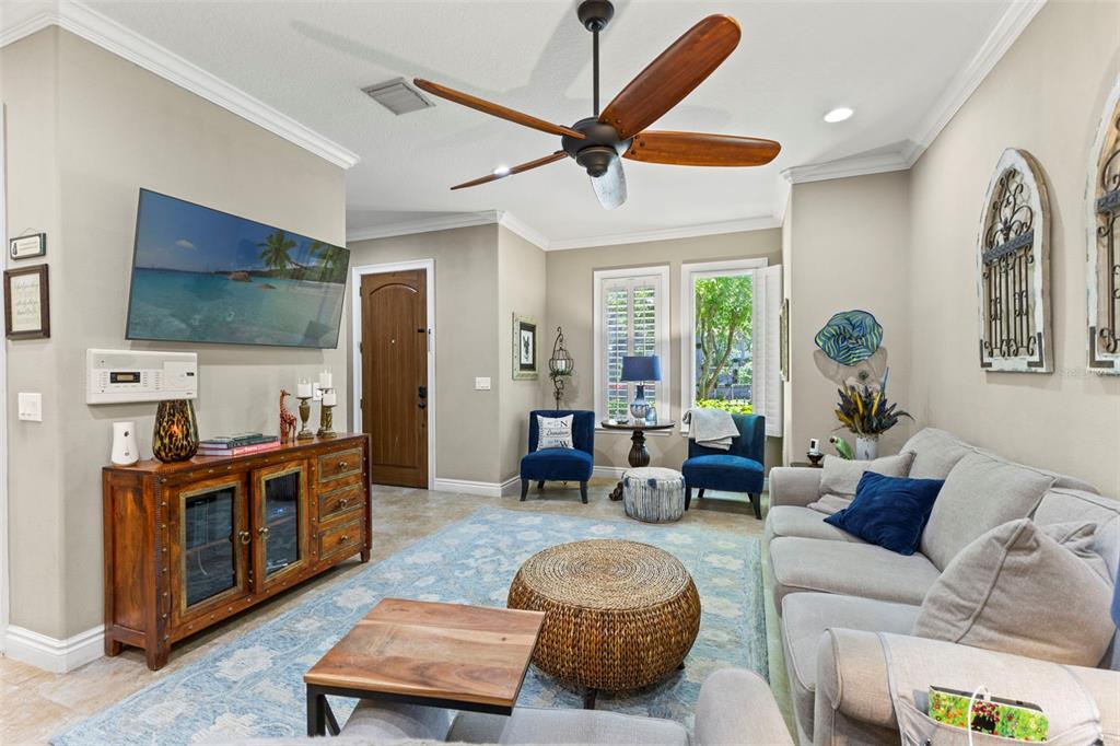 A living room features a light gray sofa, a wooden media console, and a ceiling fan — 3819 W DALE AVENUE UNIT 6, TAMPA, FL