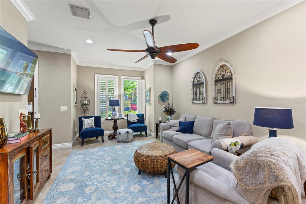 A living room features a grey sofa, two blue armchairs, a woven ottoman, and a ceiling fan — 3819 W DALE AVENUE UNIT 6, TAMPA, FL